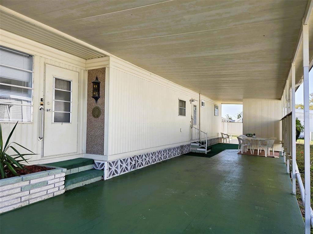 A covered concrete patio runs alongside the exterior wall of a mobile home — 3312 OVERCUP OAK TERRACE, SARASOTA, FL