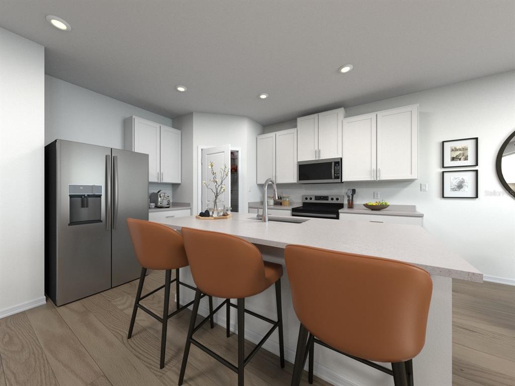 This is a rendering of a modern kitchen featuring white cabinets, stainless appliances, and island seating — 1781 FOREST RUN LANE, AUBURNDALE, FL