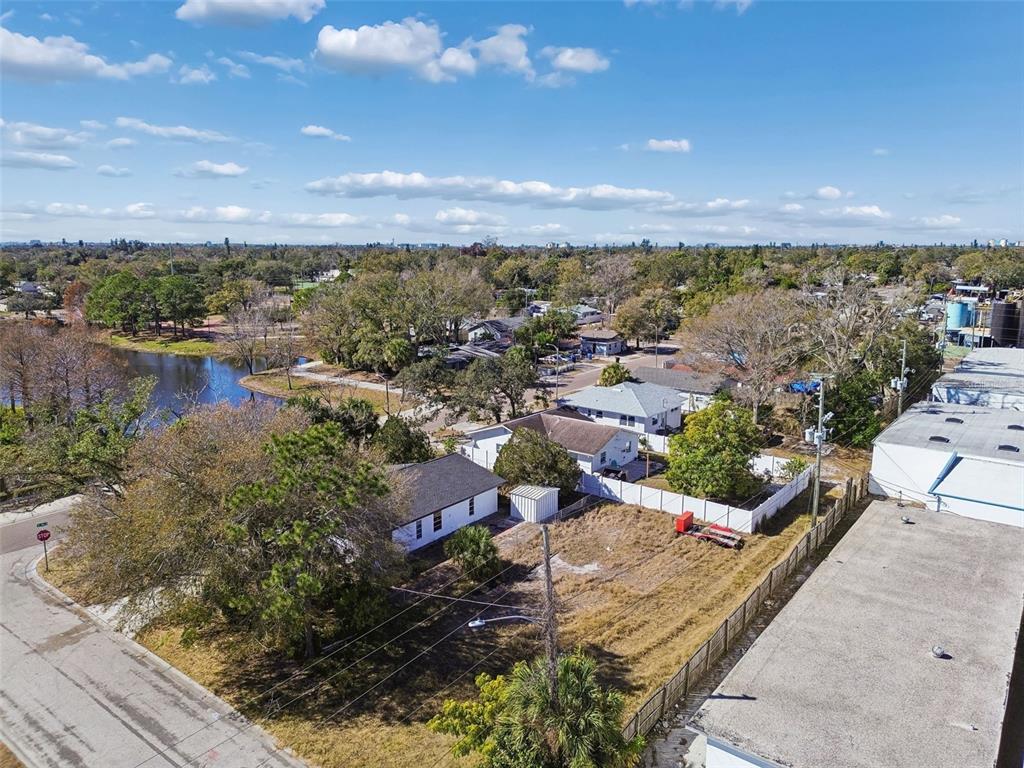 An aerial view shows a residential lot with a house next to a commercial building — 42ND ST S, ST PETERSBURG, FL