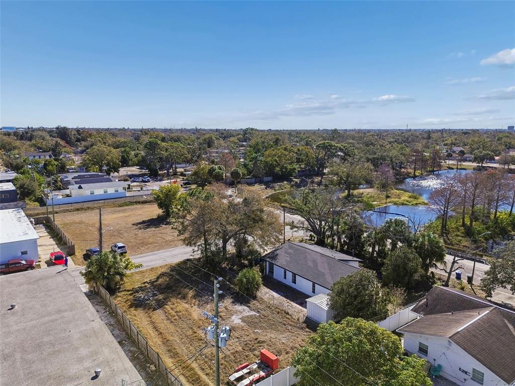 An aerial view shows a vacant lot, a small house, and a nearby pond — 42ND ST S, ST PETERSBURG, FL