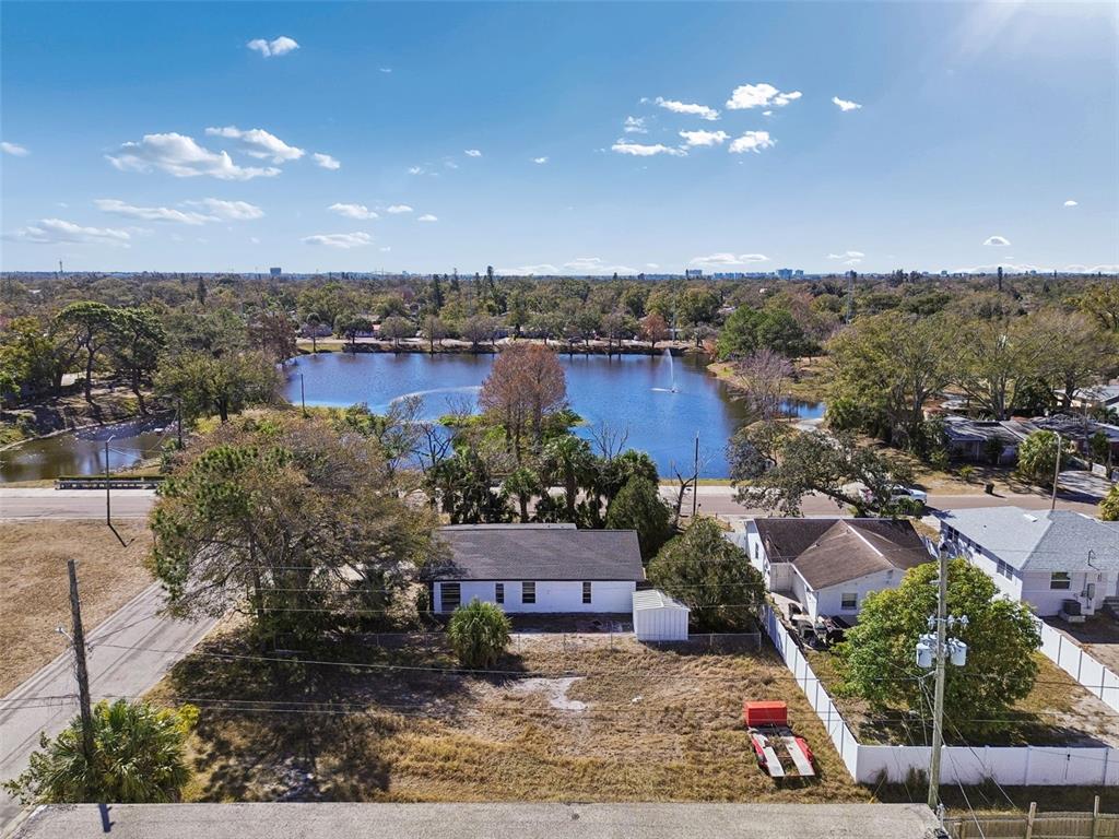 An aerial view shows a white house with a large backyard facing a lake — 42ND ST S, ST PETERSBURG, FL