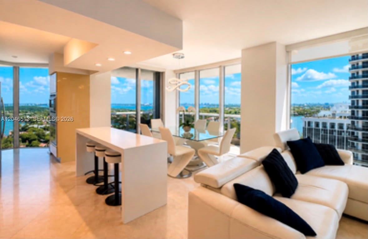 A modern open-concept living and dining area features white furniture, tile floors, and floor-to-ceiling windows — 4775 Collins Ave # 2407, Miami Beach FL 33140, MIAMI BEACH, FL