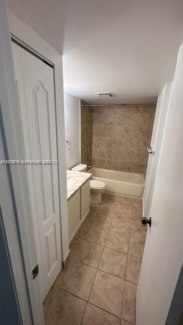 A bathroom features a vanity, a toilet, and a bathtub with tan tile walls — MIAMI, FL