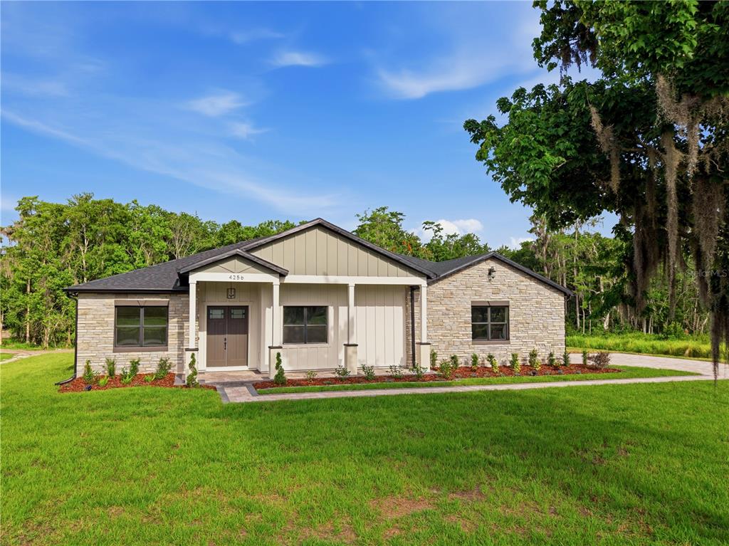 A single-story house with a stone facade and a covered entryway sits on a lawn — 4256 LA SALLE AVE, ST CLOUD, FL