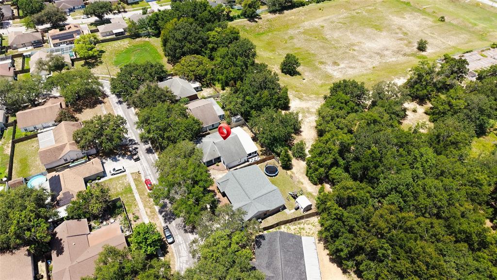 An aerial view shows a house roof, a backyard with a trampoline, and a playground set — 1048 MALLETWOOD DRIVE, BRANDON, FL
