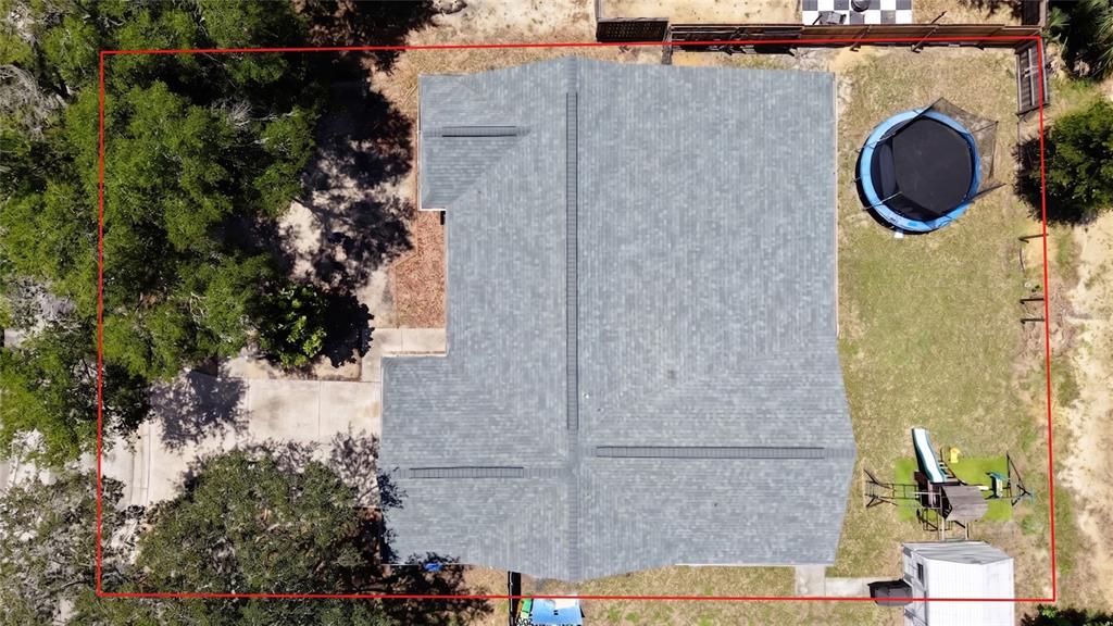 A single-story house with dark green siding, a beige garage, and a covered front porch — 1048 MALLETWOOD DRIVE, BRANDON, FL