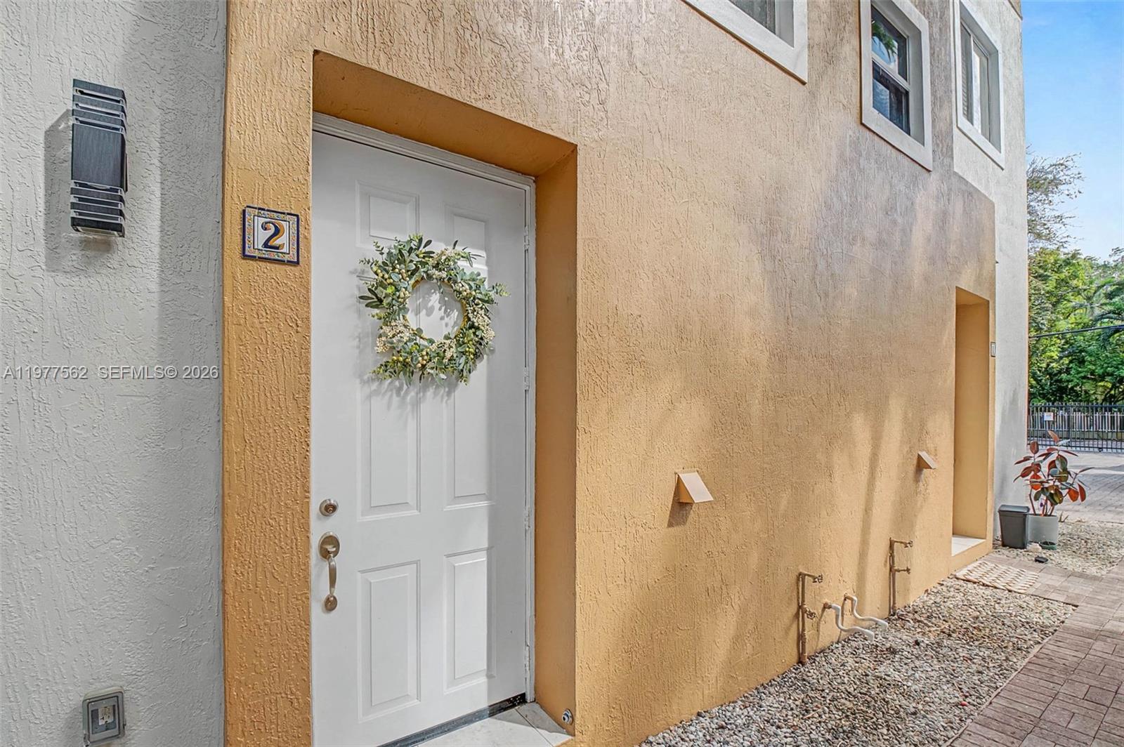 A white door with the number three is on the side of a tan building — 2945 Coconut Ave, Miami FL 33133, MIAMI, FL