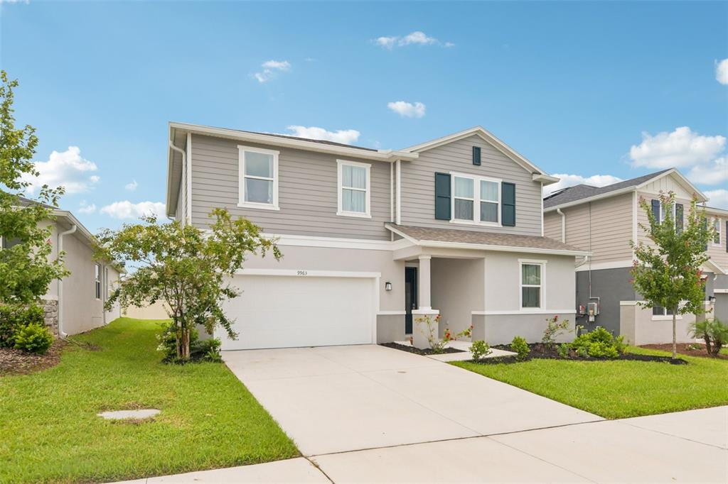 A two-story suburban house with gray siding, a white garage, and a concrete driveway — 9963 SUNRISE VIEW COURT, SEFFNER, FL