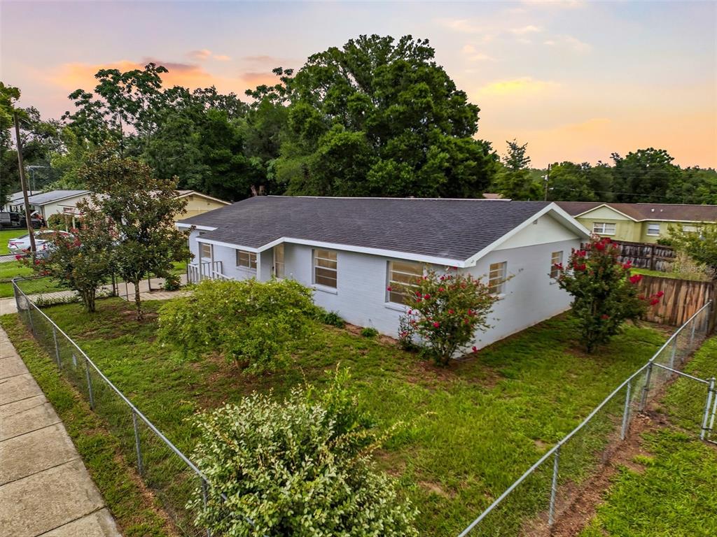 A single-story gray house with a dark shingled roof sits on a fenced grassy lot — 6376 CAMMIE STREET, BROOKSVILLE, FL