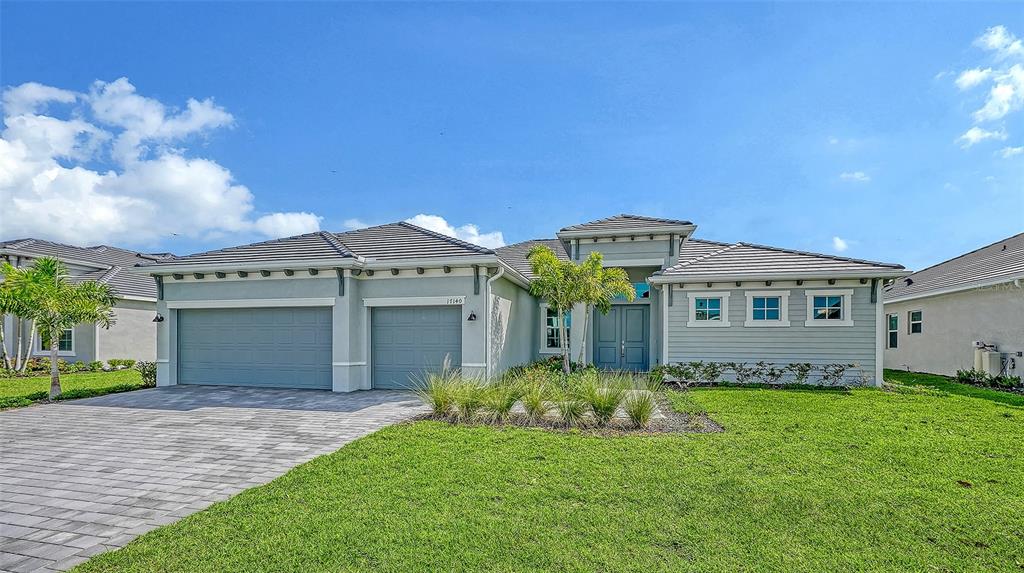 A single-story house features a gray exterior, a three-car garage, and a paved driveway — 17140 ALBATROSS ROAD, VENICE, FL