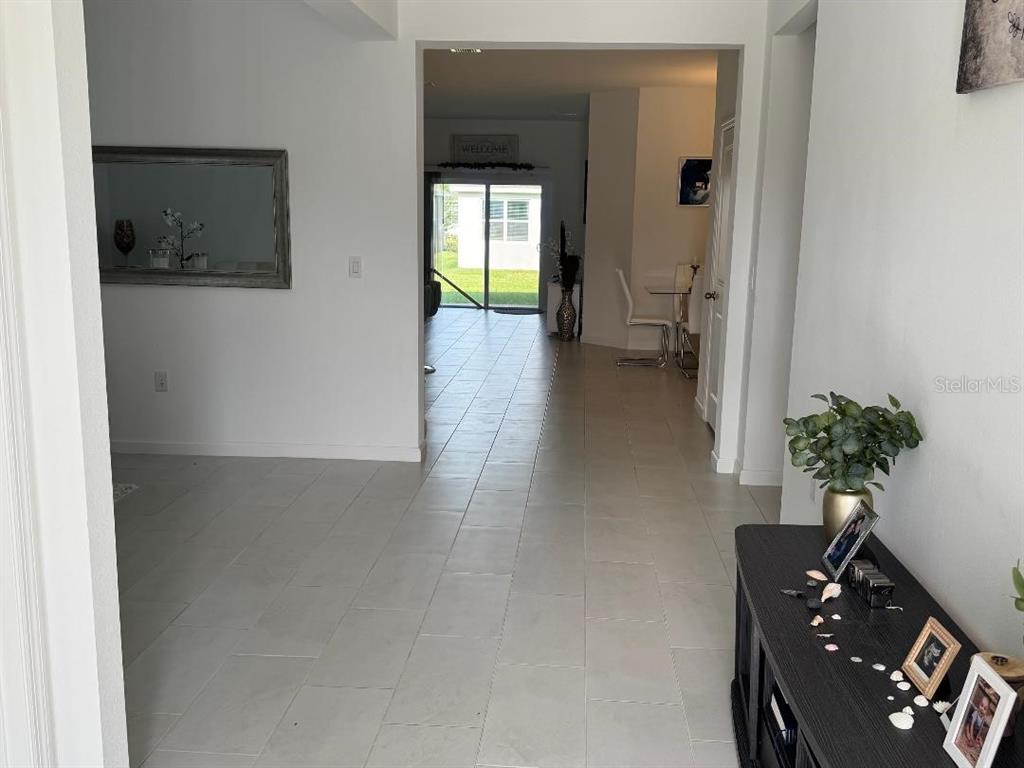 A tiled entryway leads to a living area with a sliding glass door to the backyard — 441 SILVER PALM DRIVE, HAINES CITY, FL