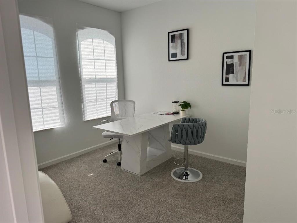 A home office features a white marble desk, two chairs, and two framed wall prints — 441 SILVER PALM DRIVE, HAINES CITY, FL