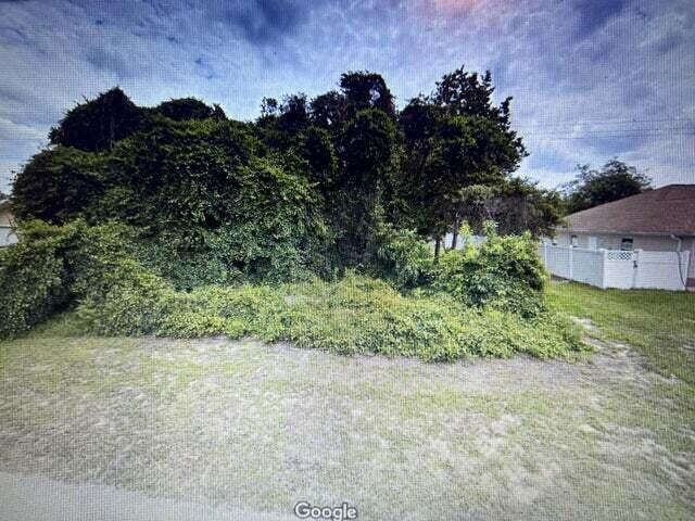 A vacant, overgrown lot with dense trees and shrubs next to a house with fencing — 2955 SW 140th Loop, Ocala FL 34473, OCALA, FL