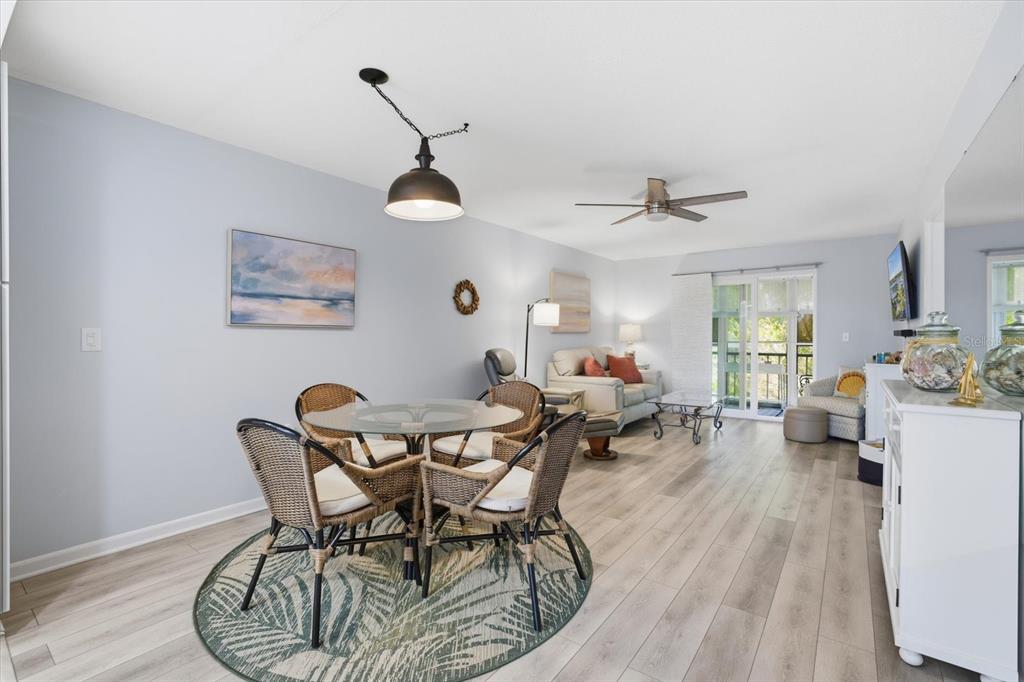 A blue front door opens to a view of an outdoor walkway with light wood flooring — 649 TAMIAMI TRAIL S UNIT 306, VENICE, FL
