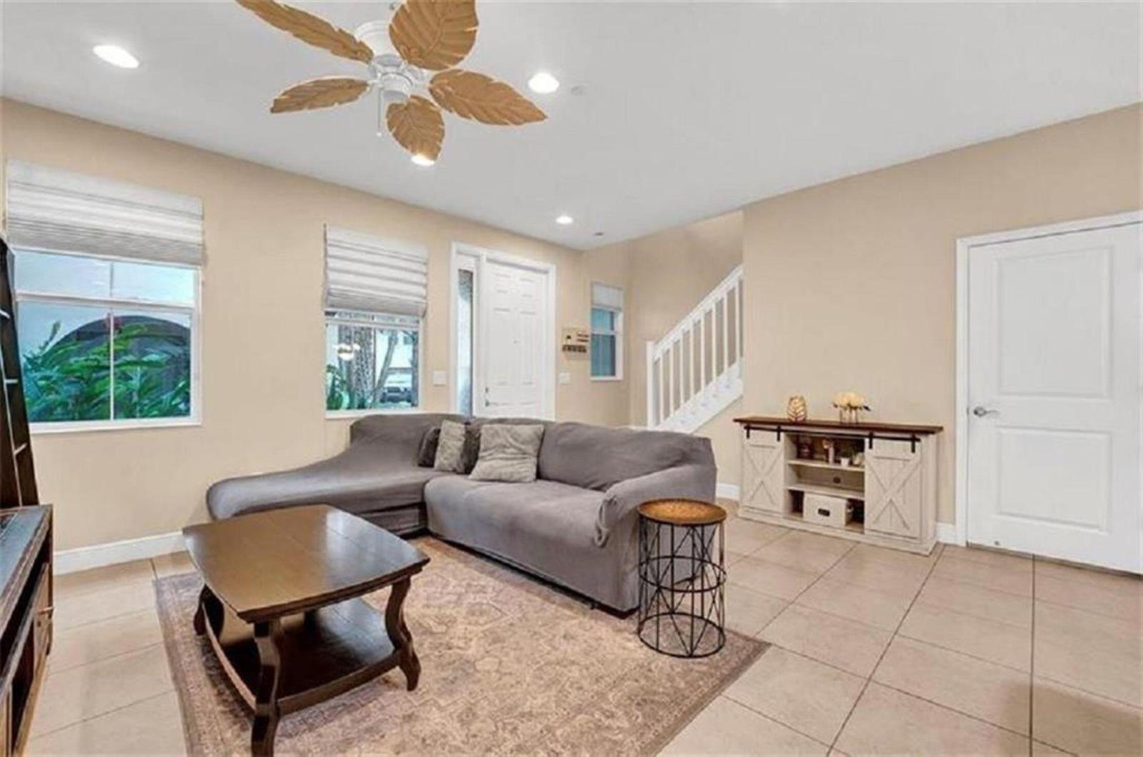 A living room features a grey sectional sofa, a coffee table, and tile flooring — 2930 Cascada Isles Way, Cooper City FL 33024, COOPER CITY, FL