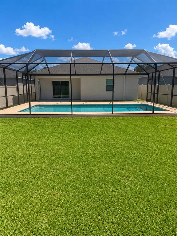 A backyard features a swimming pool enclosed by a screen cage behind a house — 2016 ROSEWOOD CIRCLE, LAKELAND, FL