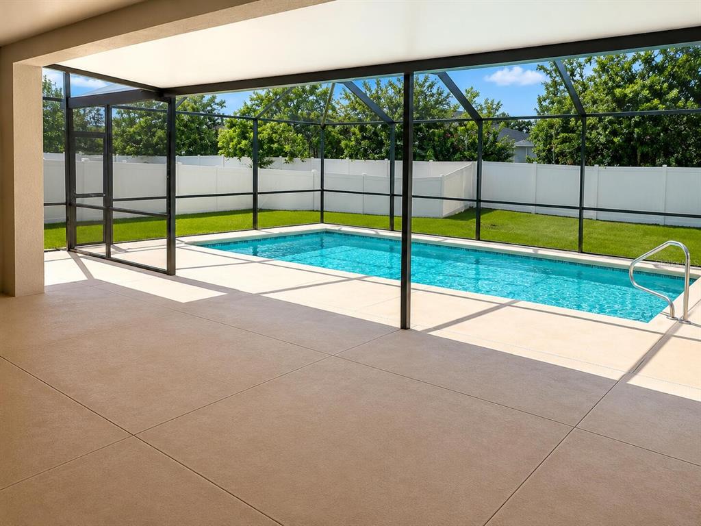 A covered patio overlooks a rectangular swimming pool enclosed by a screened lanai — 2016 ROSEWOOD CIRCLE, LAKELAND, FL
