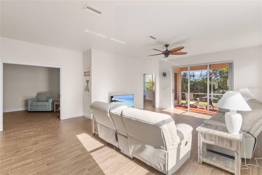 A living room features light-colored tile floors, a ceiling fan, and sliding glass patio doors — 1937 SCARLETT AVENUE, NORTH PORT, FL
