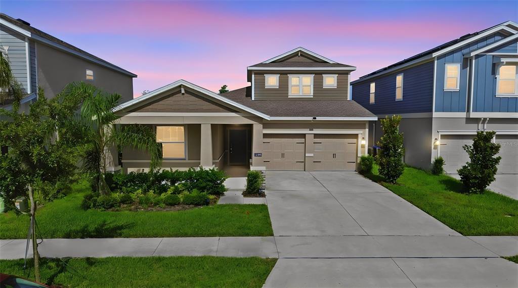 A two-story suburban house with a two-car garage and a front porch at dusk — 16448 PARABLE WAY, WINTER GARDEN, FL