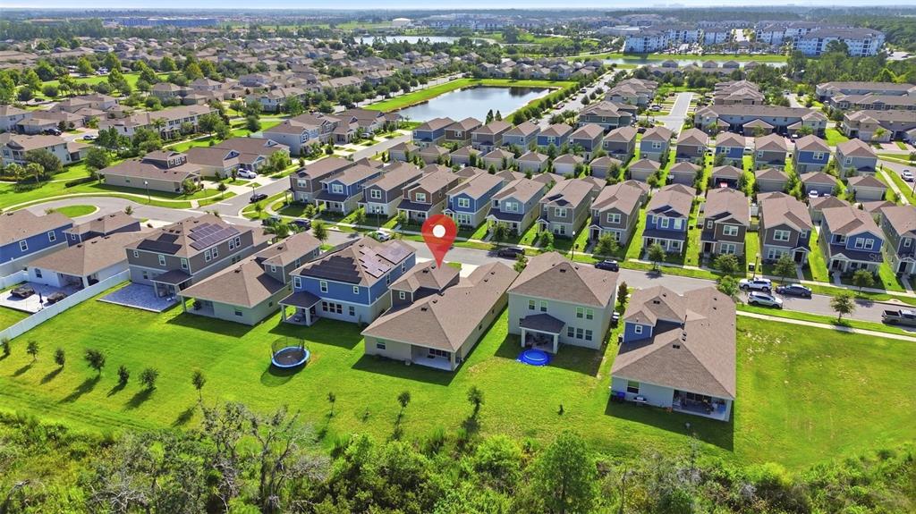 An aerial view shows a suburban neighborhood with many single-family homes and a central pond — 16448 PARABLE WAY, WINTER GARDEN, FL