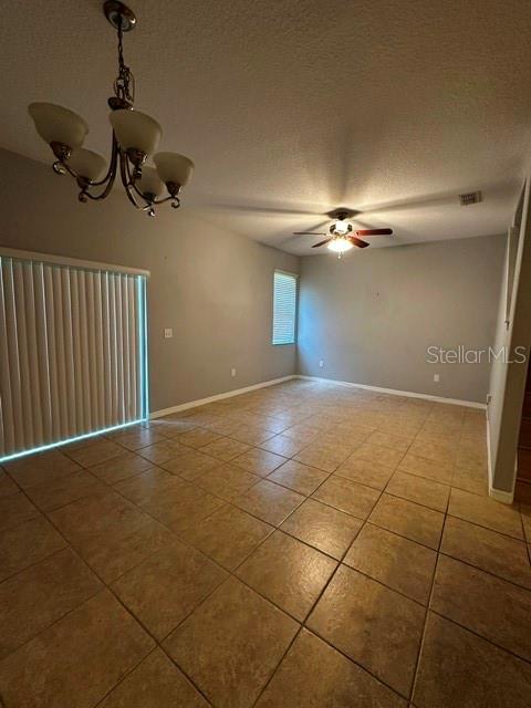 An empty room features tile flooring, a chandelier, a ceiling fan, and sliding glass doors — 11213 SAVANNAH LANDING CIRCLE, ORLANDO, FL