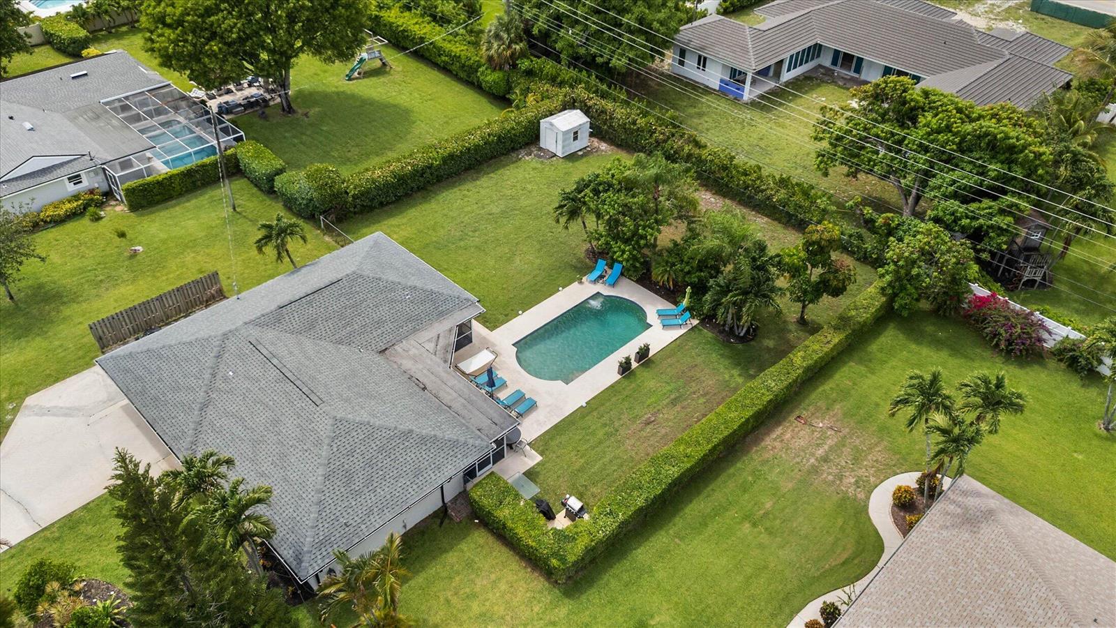 An aerial view shows a house with a swimming pool and a large fenced backyard — 3313 Sherwood Boulevard, Delray Beach FL 33445, DELRAY BEACH, FL