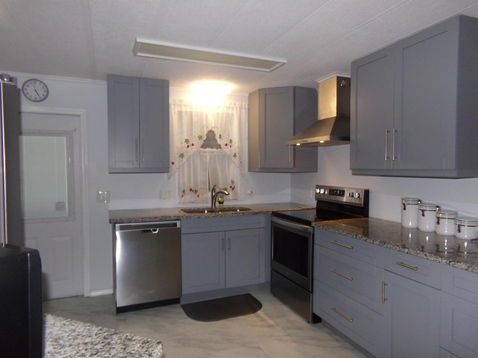A kitchen features gray cabinets, stainless steel appliances, and granite countertops — 57006 Antilles, Boynton Beach FL 33436, BOYNTON BEACH, FL