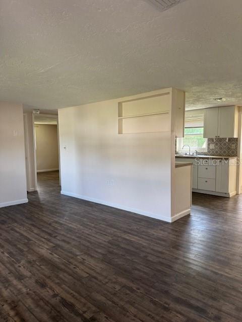 A view of a living room with wood-look flooring leading to a kitchen with white cabinets — 95 S FILLMORE STREET, BEVERLY HILLS, FL