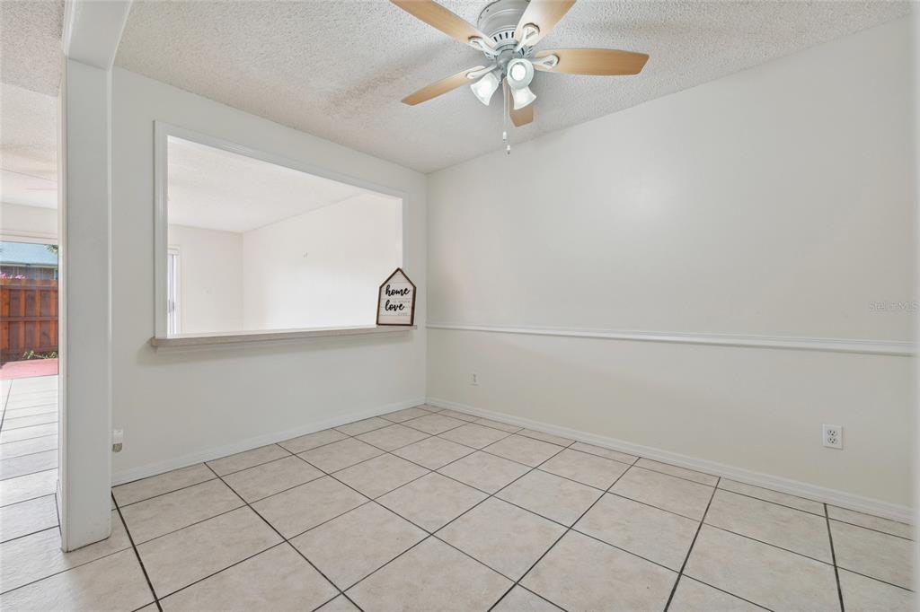 A dining area features light tile flooring, a ceiling fan, and a pass-through wall opening — 316 GEORGETOWN DRIVE UNIT 316, CASSELBERRY, FL
