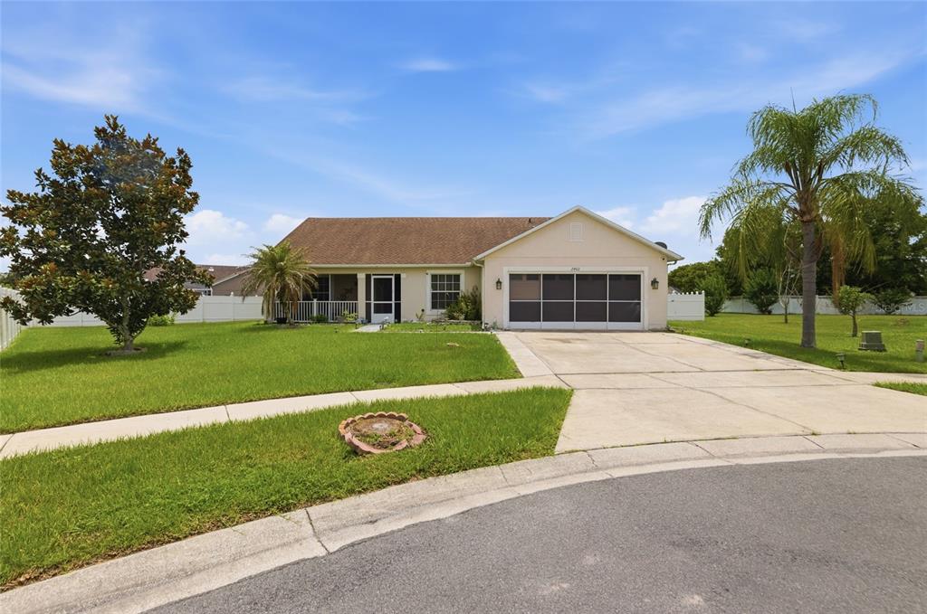A single-story house with a beige exterior, a two-car garage, and a front lawn — 2402 ACCORD TERRACE, KISSIMMEE, FL