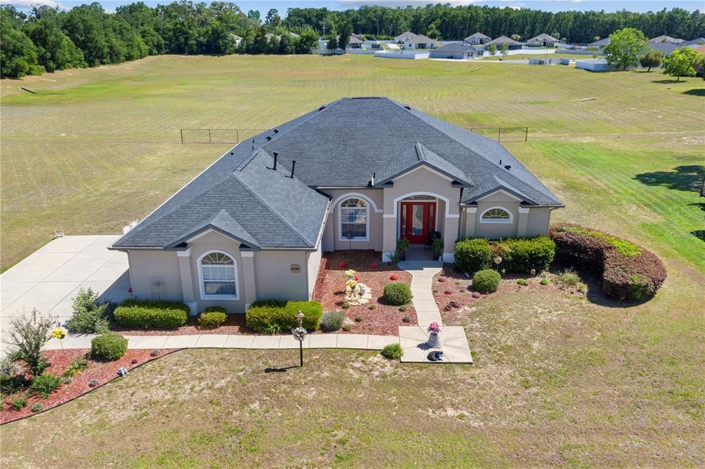 An aerial view shows a single-story house with a dark roof and red front door — 6426 SE 10TH STREET, OCALA, FL