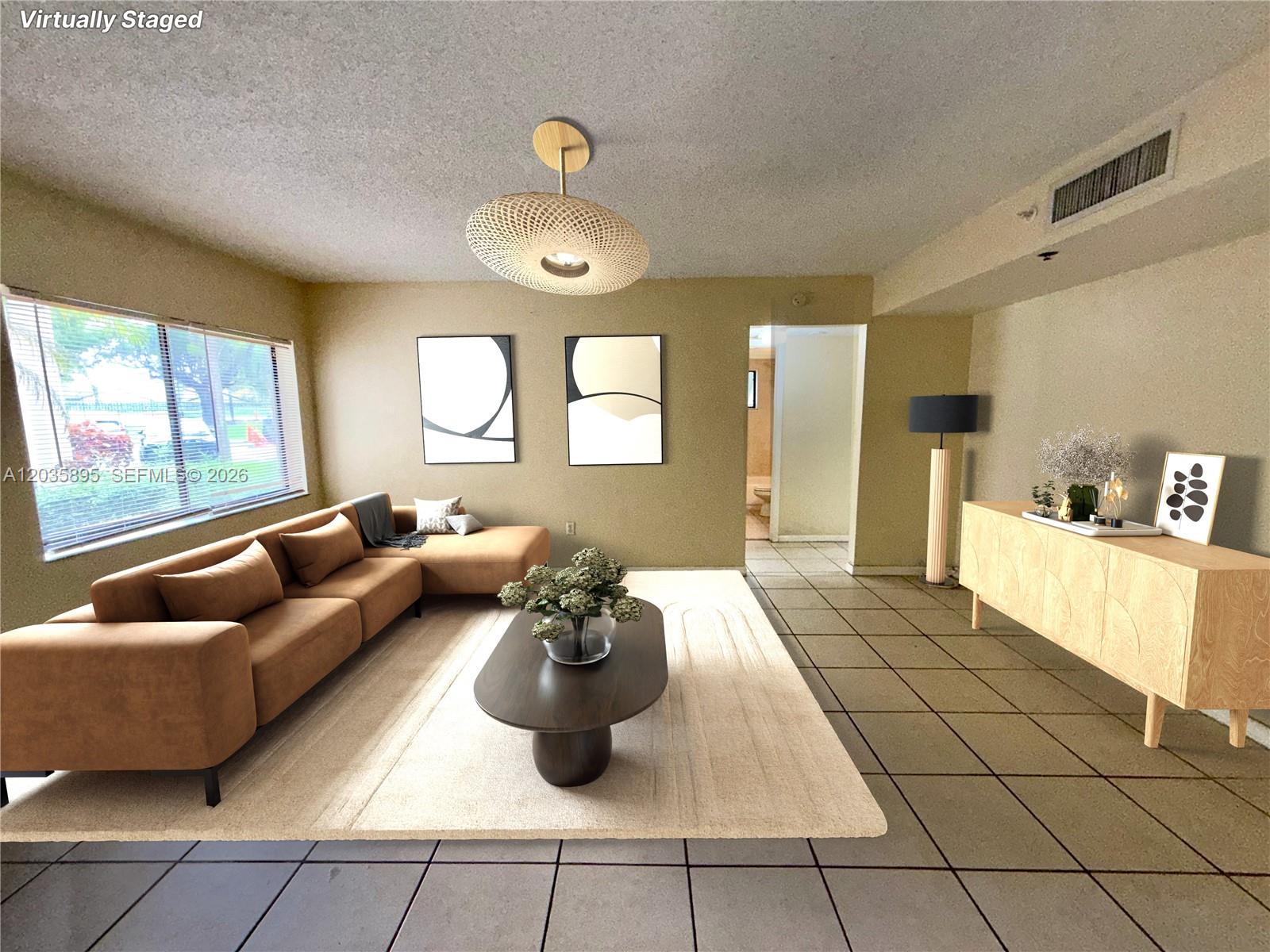 This virtually staged living room features a brown sectional sofa, area rug, and tile flooring — 8760 SW 133rd Ave Rd # 107, Miami FL 33183, MIAMI, FL