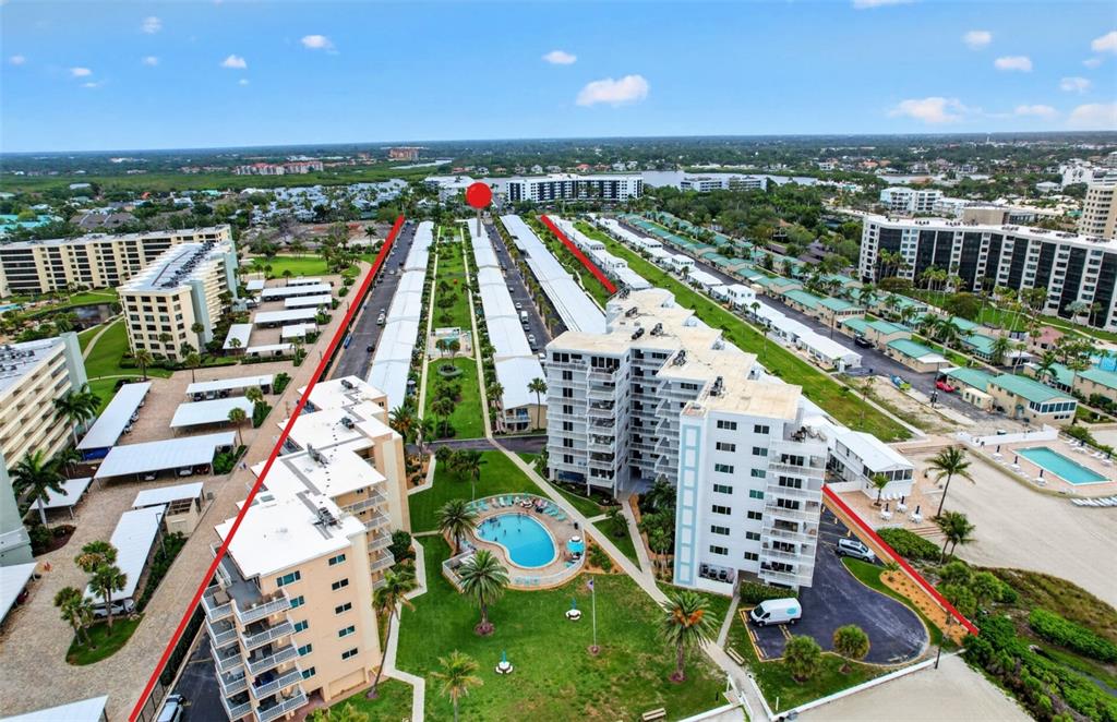 An aerial view shows a multi-building residential complex with swimming pools and landscaped grounds — 5830 MIDNIGHT PASS ROAD UNIT 48, SARASOTA, FL