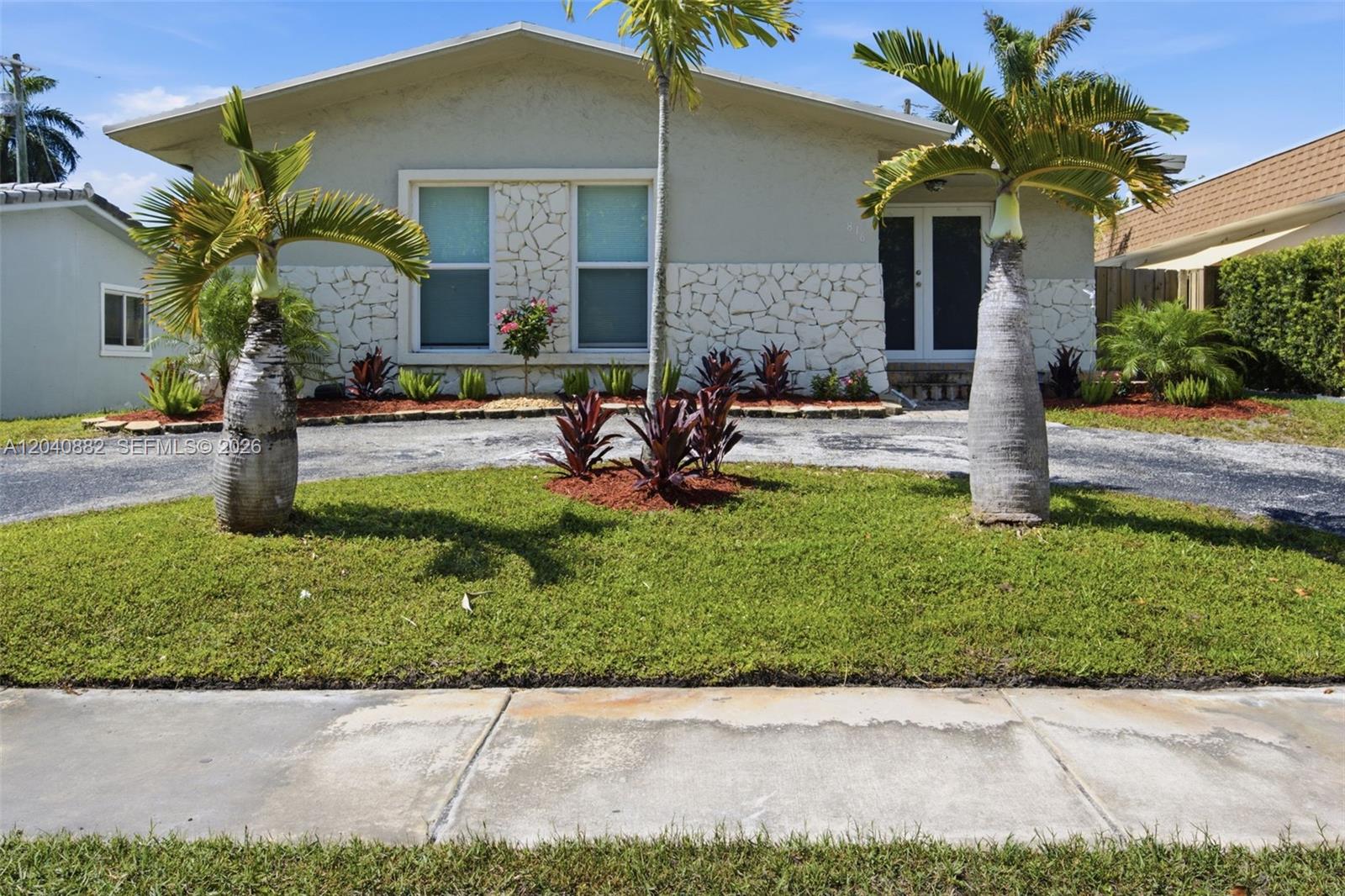 A single-story house features a stone facade, two palm trees, and a paved driveway — 816 Johnson St, Hollywood FL 33019, HOLLYWOOD, FL