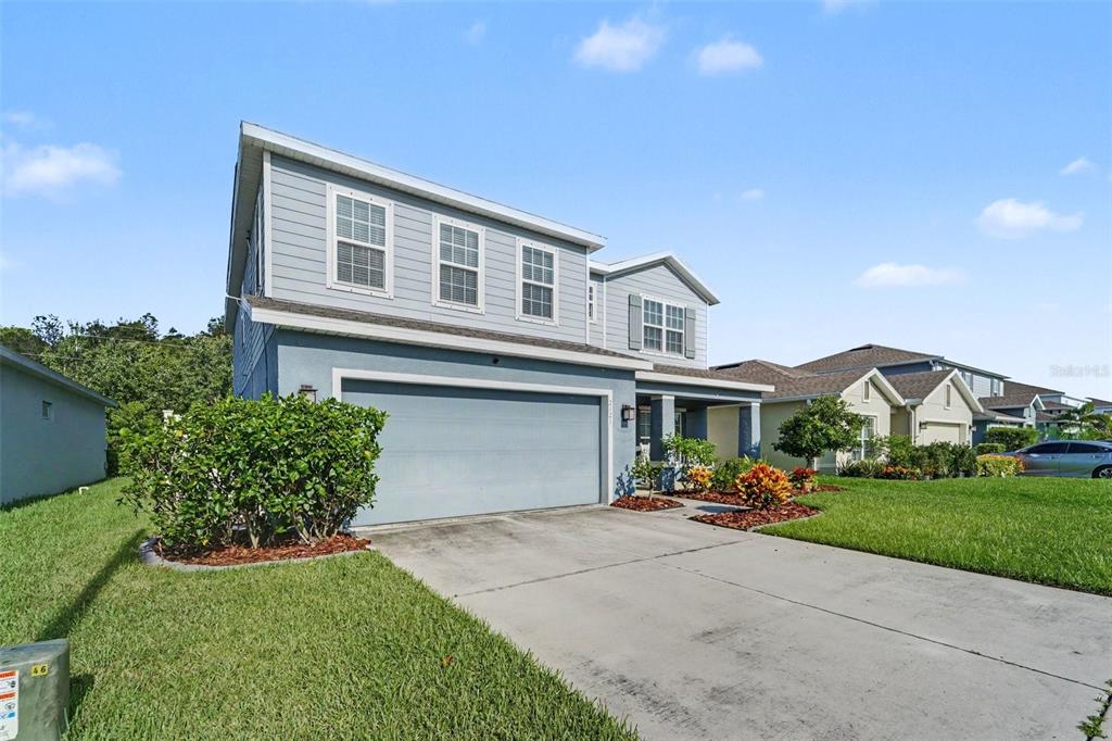 A two-story blue house with a two-car garage and a concrete driveway — 2121 BRANDING IRON COURT, TRINITY, FL