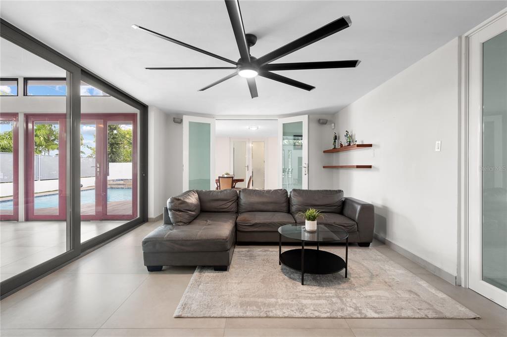 A living room features a grey sectional sofa, a round coffee table, and a ceiling fan — 840 MALAGA, GUAYNABO, PR