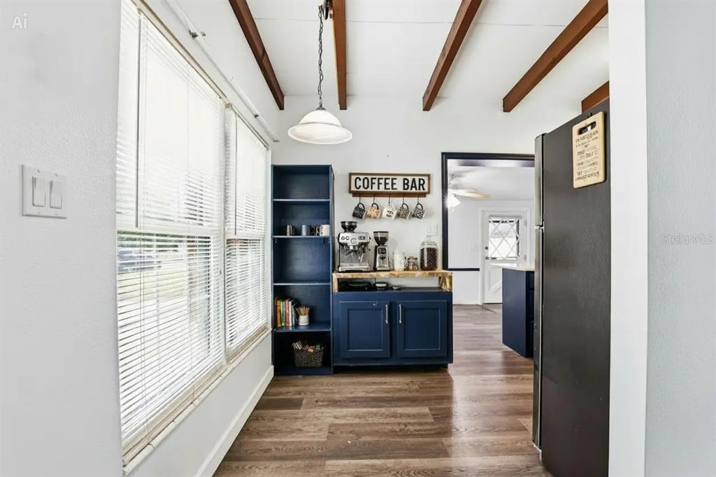 A kitchen features white upper cabinets, dark blue lower cabinets, stainless steel appliances, and quartz countertops — 713 W 116TH AVENUE, TAMPA, FL