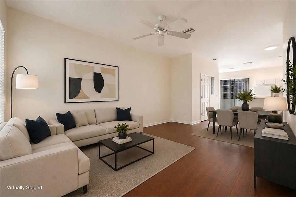 A virtually staged living and dining area with wood floors and a ceiling fan — 11676 DECLARATION DRIVE, TAMPA, FL
