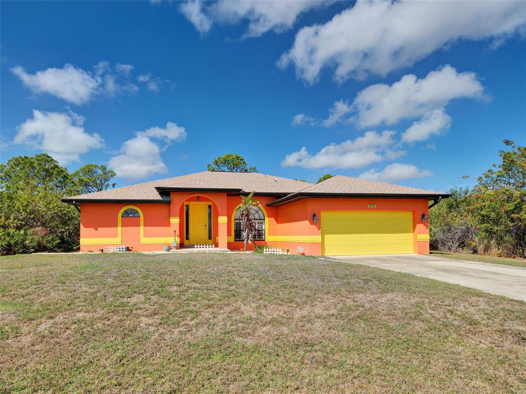 A single-story house with bright orange stucco walls, yellow trim, and a yellow garage door — 2135 BELVOIR STREET, PORT CHARLOTTE, FL