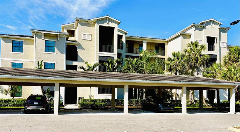 A multi-story apartment building with a covered parking structure in the foreground — 17724 GAWTHROP DRIVE UNIT 308, BRADENTON, FL