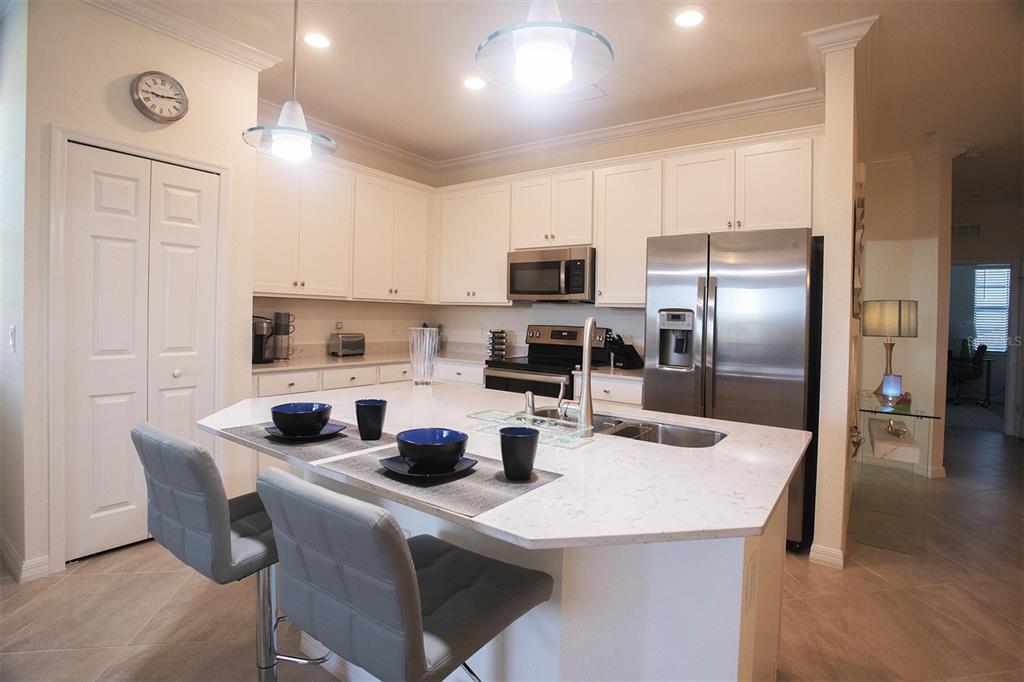 A kitchen with white cabinets, stainless steel appliances, and a central island with bar seating — 17724 GAWTHROP DRIVE UNIT 308, BRADENTON, FL