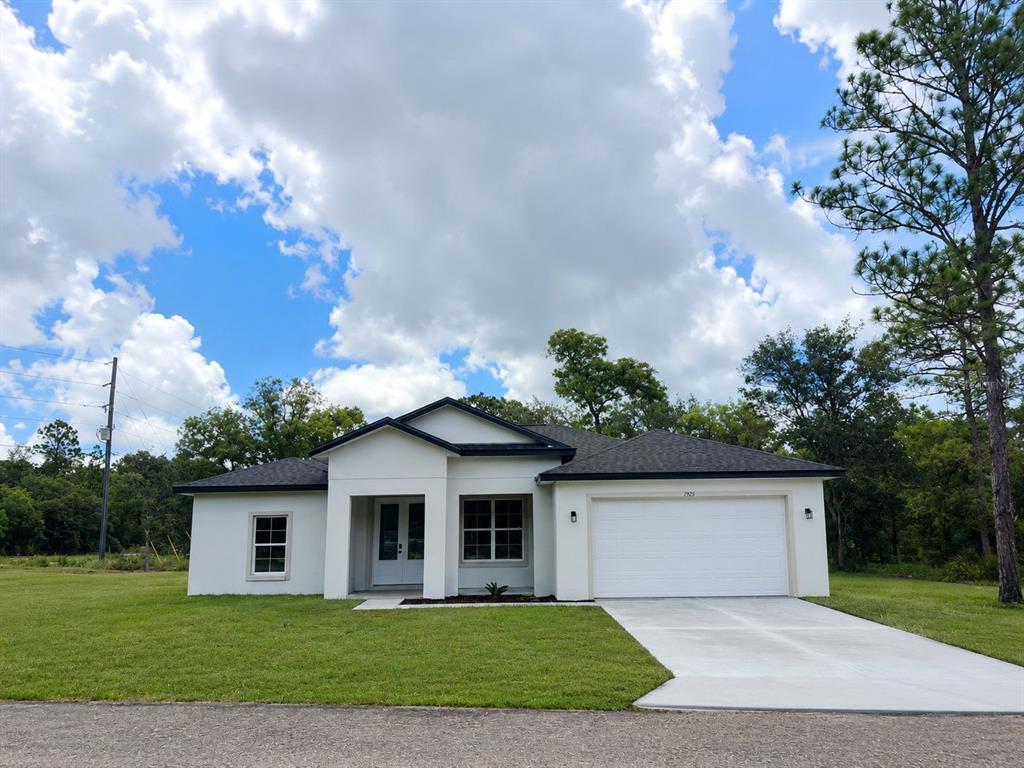 A single-story house with white stucco walls, a dark roof, and a two-car garage — 7325 N GALT POINT, CITRUS SPRINGS, FL