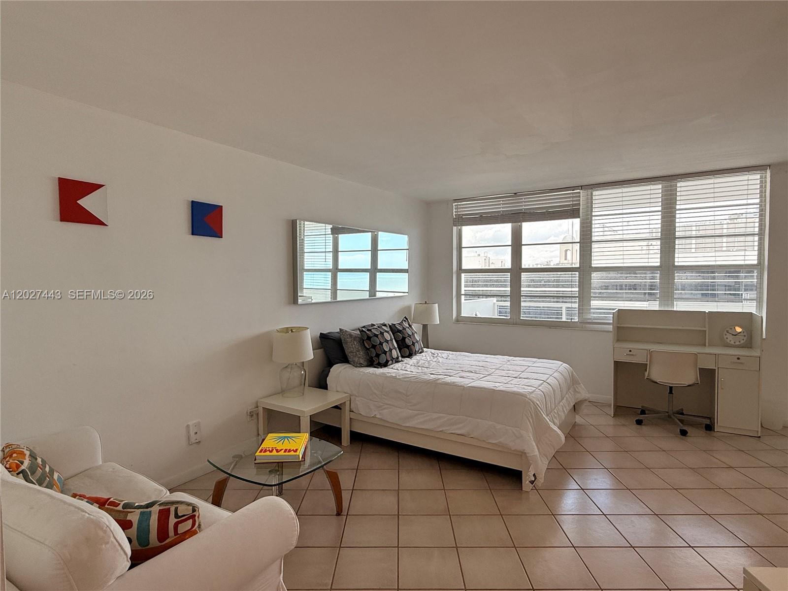 A bedroom features a white bed, a desk, a glass coffee table, and tiled floors — 100 Lincoln Rd # 1427, Miami Beach FL 33139, MIAMI BEACH, FL