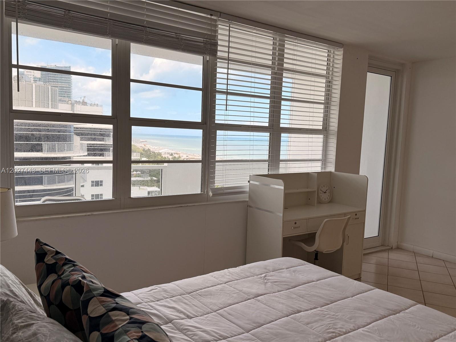 A bedroom features a bed, a white desk, and large windows with an ocean view — 100 Lincoln Rd # 1427, Miami Beach FL 33139, MIAMI BEACH, FL