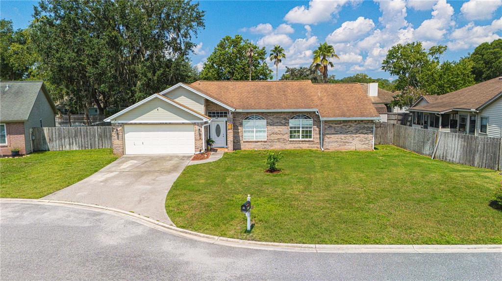 A single-story brick and siding house with a two-car garage and a front lawn — 2028 CANYON RIM PLACE, MIDDLEBURG, FL