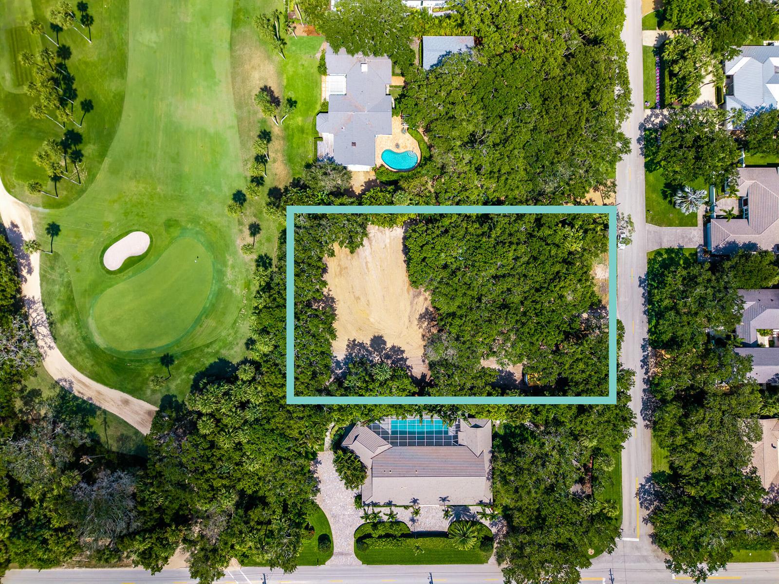 Aerial view of a vacant, partially wooded residential lot situated next to a golf course — VERO BEACH, FL