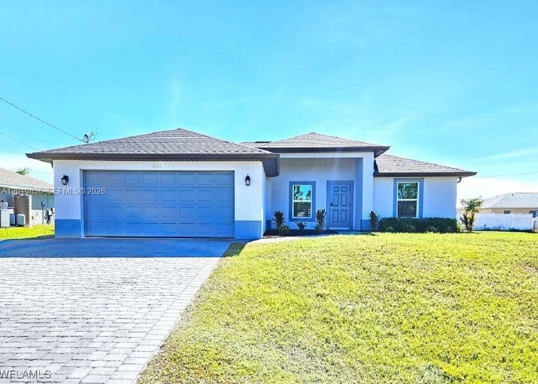 A single-story house with a blue garage door, white stucco exterior, and a paved driveway — 604 WILMINGTON, Cape Coral FL 33993, CAPE CORAL, FL