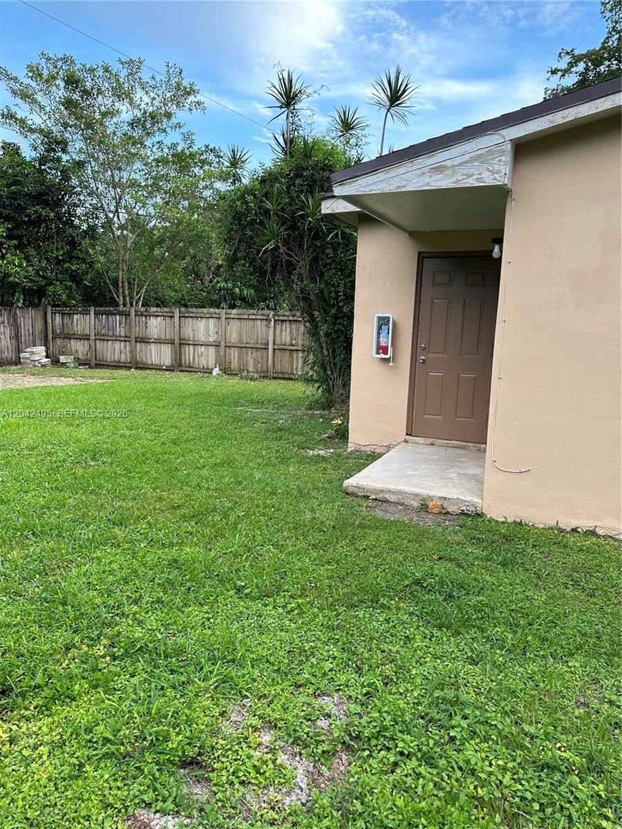 A brown exterior door is set into a tan wall beside a small concrete stoop — 22851 SW 157th Ave # 1, Miami FL 33170, MIAMI, FL