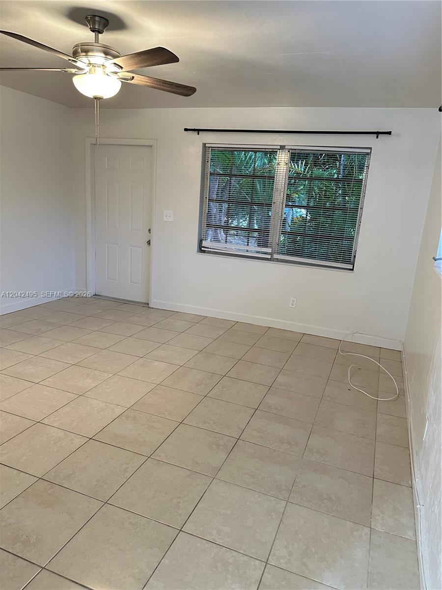 This room features light-colored tile flooring, a ceiling fan, a window with blinds, and a door — 22851 SW 157th Ave # 1, Miami FL 33170, MIAMI, FL