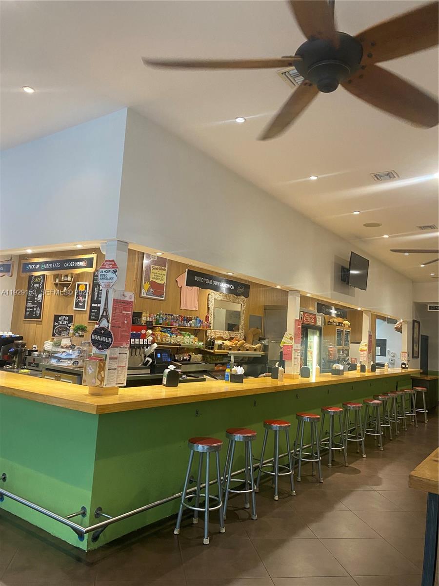 A commercial kitchen counter with bar stools and a ceiling fan in a dining area — 34 SW 8TH ST, Miami FL 33130, MIAMI, FL